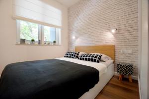 尤斯托尼莫斯基Apartament 27 Dwie Sosny的一间卧室设有一张大床和砖墙