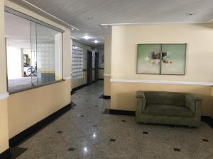 瓜鲁雅Apartamento Pitangueiras的大楼内带椅子的等候室