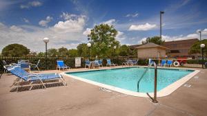 达拉斯贝斯特韦斯特西北酒店的一个带蓝色椅子的游泳池和一个泳池景泳池