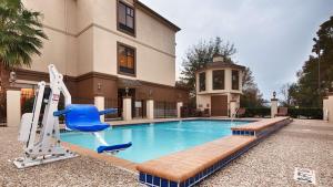 休斯顿北休斯顿贝斯特韦斯特普拉斯酒店及套房的一个带蓝色椅子的游泳池