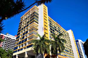 巴西利亚ABC公寓式酒店的一座高大的建筑,前面有棕榈树