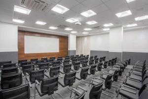 里约热内卢Samba Rio Convention & Residence的一间空的讲座室,配有黑色椅子和白色板