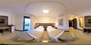 新韦内扎Hotel Dolomiti Caravaggio的一间客厅,客厅内配有两张床