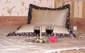 大特尔诺沃Guest Rooms Bela Neda的床上坐着两杯红葡萄酒