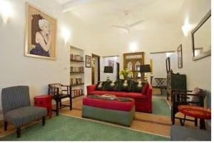 新德里Zaza Stay的客厅配有红色的沙发和椅子