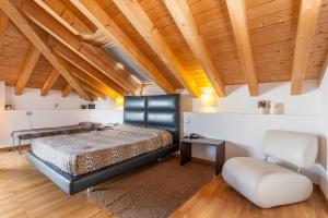 里耶卡威尼托EX-L酒店的一间卧室设有一张床、一把椅子和木制天花板
