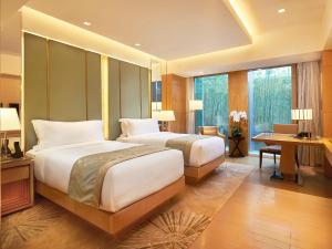 北京北京泛太平洋酒店的酒店客房配有两张床、一张书桌和一张书桌。