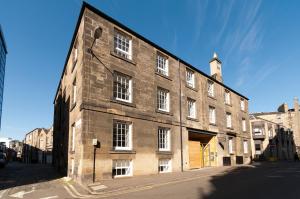 爱丁堡情定苏格兰 - 麦芽酒舍公寓酒店的街道上一座带白色窗户的大型砖砌建筑