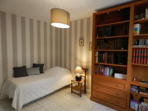 卡尔萨克阿亚克La Sembelie的一间卧室设有一张床和一个书架
