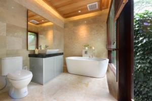 昆达桑春园酒店的带浴缸、卫生间和盥洗盆的浴室