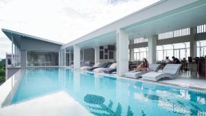 奈扬海滩Panphuree Residence - SHA Extra Plus的一座游泳池,里面的人坐在椅子上