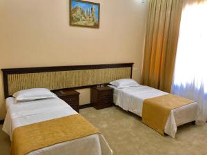 萨马尔罕穆扎法尔酒店 客房内的一张或多张床位