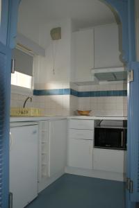 格雷乌莱班莱斯格兰特皮因斯住宅酒店的白色的厨房配有白色橱柜和水槽