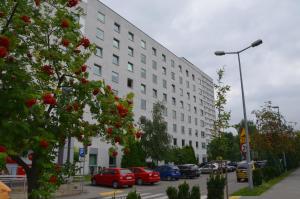 克拉科夫迪斯扎克鲁纳米酒店的一座白色的大建筑,汽车停在停车场