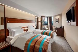 萨拉热窝萨拉热窝布里斯托尔诺富特酒店的酒店客房设有两张床和一台平面电视。
