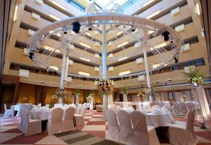 新庄新庄翰品酒店的宴会厅配有白色的桌椅和吊灯