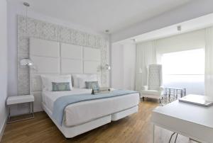 潘普洛纳Hotel Tres Reyes Pamplona的白色卧室配有一张大床和椅子