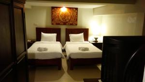 Sawankhalok萨旺卡布里精品酒店的一间带两张床和电视的卧室