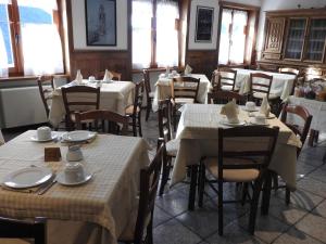 尚波吕克克劳施尔酒店的用餐室配有桌椅,提供白色菜肴
