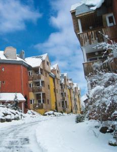 科特雷Lagrange Vacances Le Domaine des 100 Lacs的大楼前有雪覆盖的街道