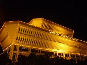 诗巫H Homestay Sibu - 500Mbps Wifi, Full Astro & Private Parking!的一座晚上点亮的建筑,灯光黄色