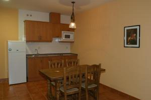 钦琼Hotel y apartamentos La Casa Rural的厨房配有木桌和白色冰箱。