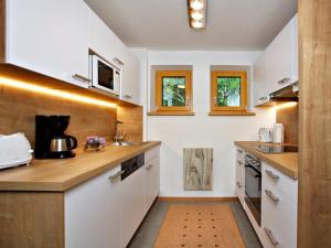 米特尔巴赫马尔格雷特公寓的厨房配有白色橱柜和木制台面