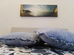 圣安吉罗山Le Casette nel Rione的床上的2个枕头,墙上有绘画作品