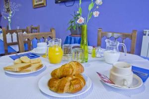 奧瑞那艾尔肯提噢客栈酒店的一张桌子,上面放着羊角面包和面包,还有橙汁