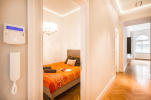 布达佩斯BpR歌剧院勒克斯宝藏公寓的一间卧室配有一张带橙色毯子的床