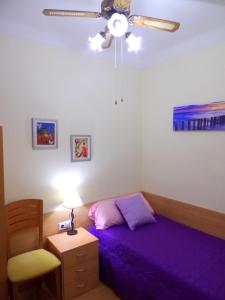 阿利坎特Explanada Beach Deluxe Flat的一间卧室配有紫色的床和吊扇
