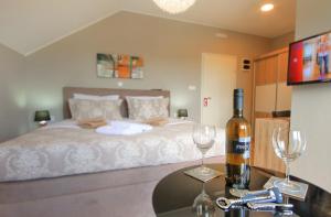 格拉博瓦茨Donna Plitvice Lakes的一间卧室配有一张床,桌子上放着两杯酒杯