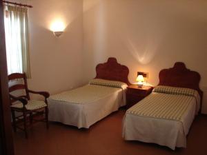 普里埃格·德·科尔多巴Villa Turística de Priego的酒店客房,配有两张床和椅子