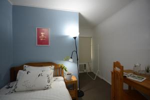 公主港阿莫尔之地宾馆的一间卧室配有一张床、一张桌子和一盏灯