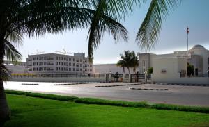 塞拉莱Gateway Salalah Apartments的前面有棕榈树的建筑