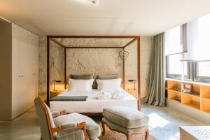 波尔图Armazém Luxury Housing- Architectural & Design Hotel的一间卧室配有一张床和一把椅子