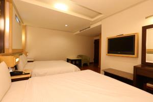 桃园市凯富旅馆 的酒店客房设有两张床和一台平面电视。