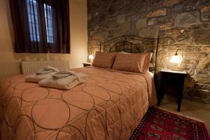 埃诺克欧拉Althaia的一间卧室设有一张带石墙的大床