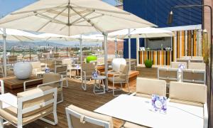 埃普拉特约布里加Salles Ciutat del Prat Barcelona Airport的一间设有白色桌椅和遮阳伞的餐厅