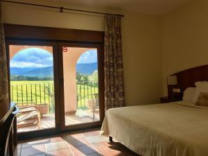 Brunyola马斯多克酒店的一间卧室设有一张床和一个美景阳台