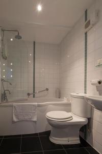 南凯夫Green Dragon, Welton by Marston's Inns的浴室配有卫生间、浴缸和水槽。