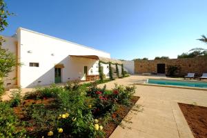 佩斯科勒海滨Relais Masseria Sant'Antonio的一座带游泳池和花园的房屋