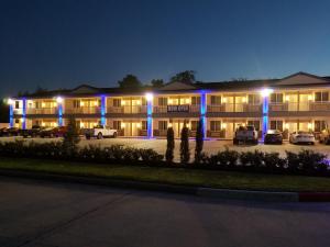 休斯顿Palace Inn Blue Tomball Parkway的停车场内有蓝色灯光的建筑
