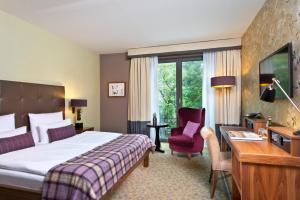 汉堡汉堡乌伦霍斯特阿斯匹亚酒店的酒店客房配有一张床、一张桌子和一把椅子。