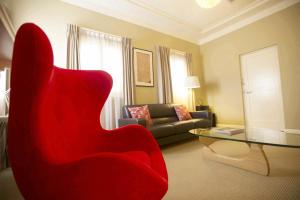 沃加沃加环球公寓酒店的客厅配有红色椅子和沙发