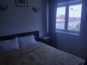 斯法克斯Hotel El Layeli的一间卧室设有一张大床和大窗户