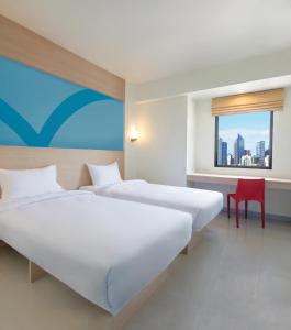 马尼拉Hop Inn Hotel Makati Avenue Manila的配有窗户的酒店客房内的两张床