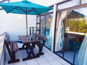 马盖特Dumela Margate Flat No 5的阳台上的野餐桌和遮阳伞