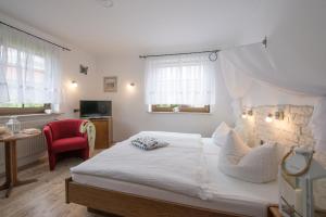 米德尔哈根米德尔哈根黛琪格拉芙旅馆的卧室配有白色的床和红色椅子