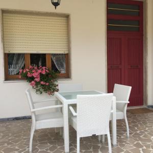 马帝斯兹罗La Perla del Mare的白色的桌子和椅子,红色的门
